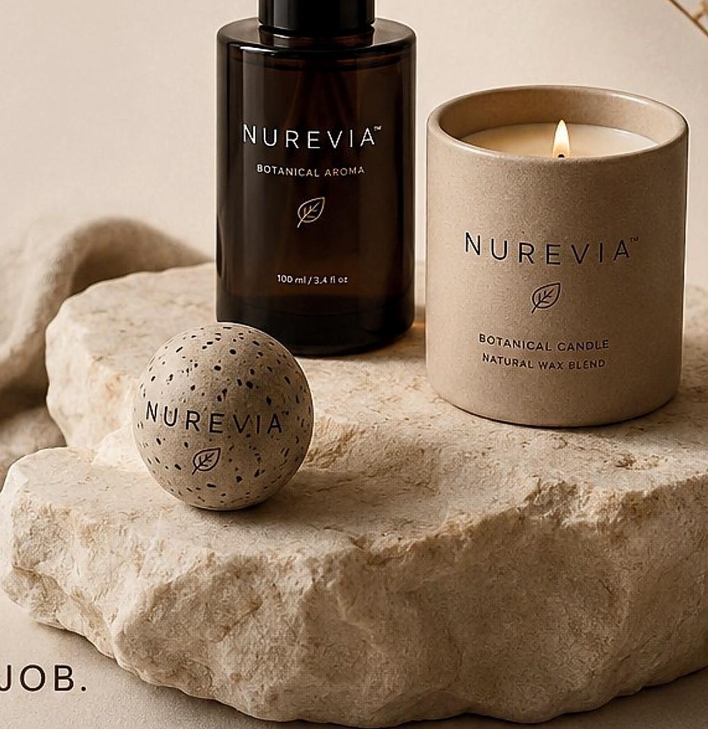 NUREVIA botanical diffuser, candle and Activation Sphere on natural stone